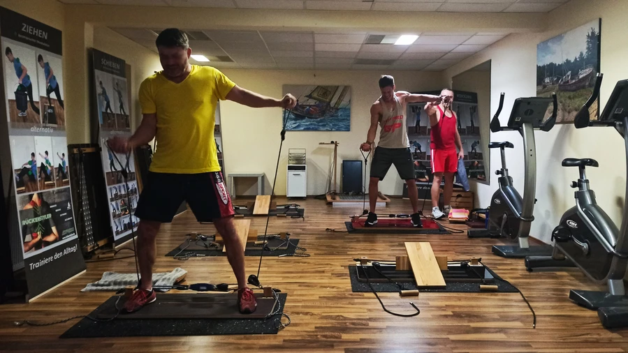 2 Männer im Fitnessstudio trainieren an Dewboard Pro smart